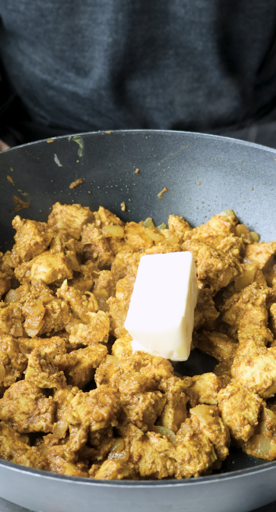 greek yogurt and garlic and spices in chicken and diced onion and butter